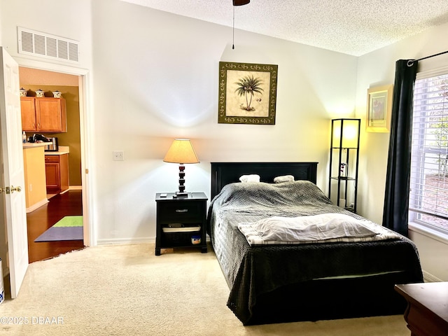 bedroom with baseboards, carpet, visible vents, and a textured ceiling