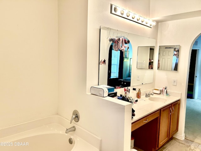 ensuite bathroom with ensuite bathroom, a bath, and vanity