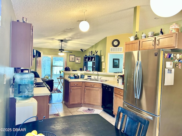 kitchen with a peninsula, light countertops, dishwasher, and freestanding refrigerator