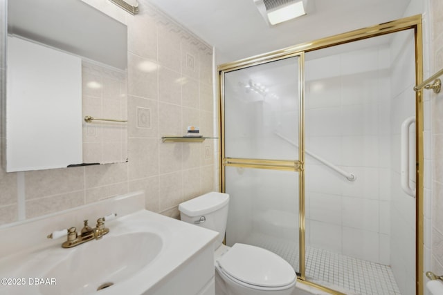 bathroom with tile walls, vanity, toilet, and walk in shower