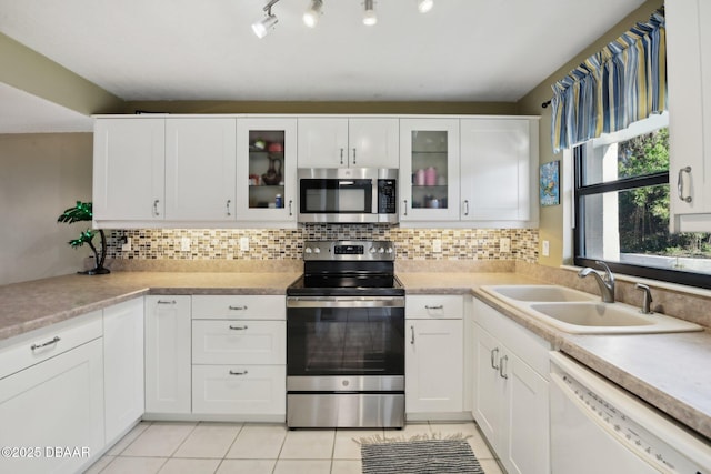 kitchen with stainless steel appliances, sink, decorative backsplash, and white cabinets