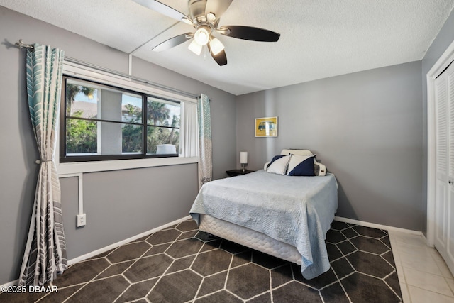 bedroom with ceiling fan, a closet, and a textured ceiling