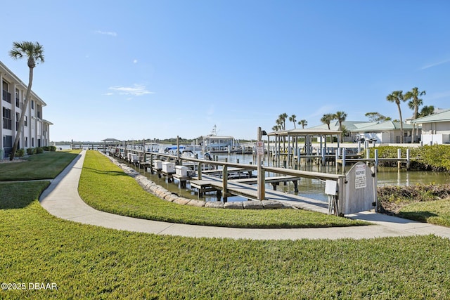 view of dock with a water view and a lawn