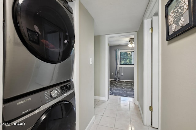 clothes washing area with ceiling fan, stacked washer and clothes dryer, and light tile patterned floors