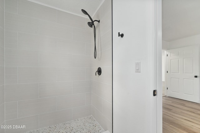 bathroom featuring a tile shower and wood finished floors