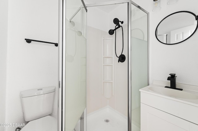 full bath with vanity, a shower stall, and toilet