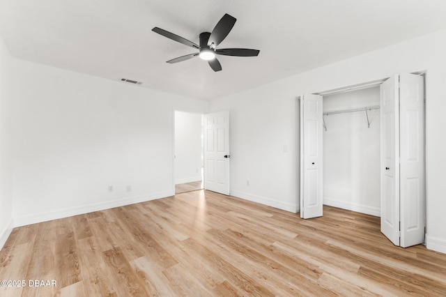 unfurnished bedroom featuring a closet, baseboards, visible vents, and light wood finished floors