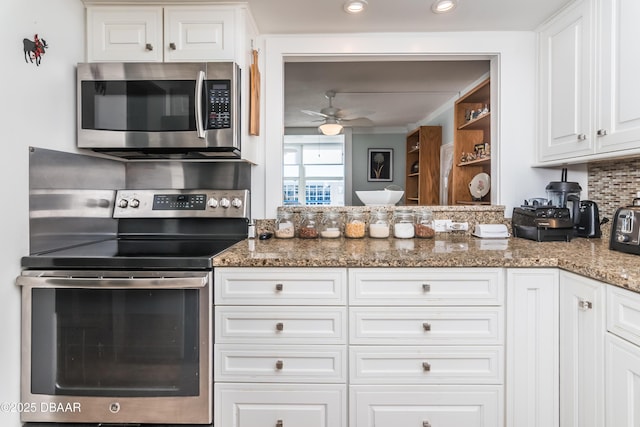 kitchen featuring white cabinetry, ceiling fan, stainless steel appliances, tasteful backsplash, and dark stone counters