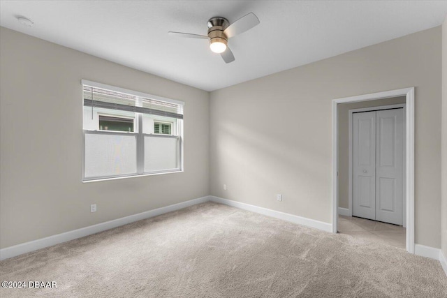 spare room featuring ceiling fan and light carpet