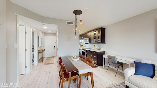 3170 Ocean Shore Blvd Unit 105, Ormond Beach, FL 32176 - dining space with light wood-style floors, recessed lighting, and bar area