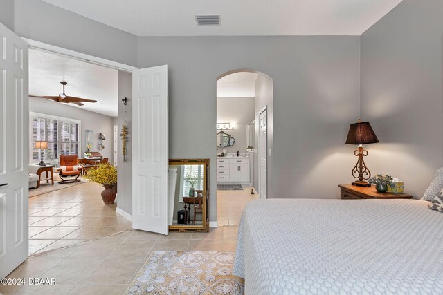 tiled bedroom with ceiling fan and connected bathroom