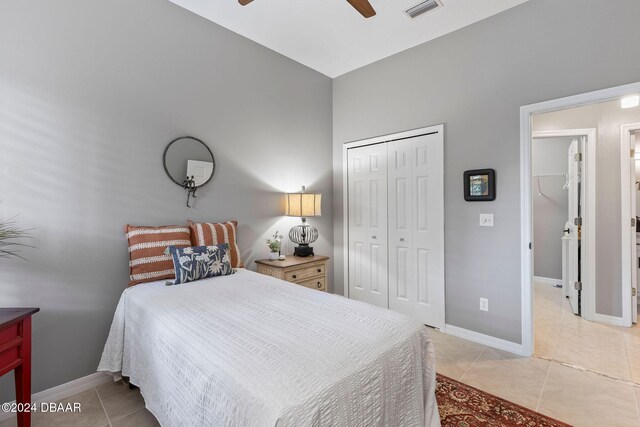 tiled bedroom with ceiling fan and a closet