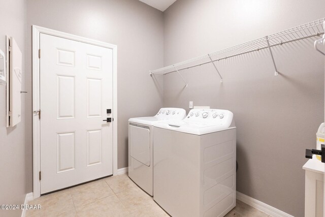 laundry area featuring washer and clothes dryer and light tile patterned floors