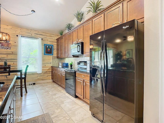 kitchen featuring black appliances, wooden walls, tasteful backsplash, and light tile patterned floors