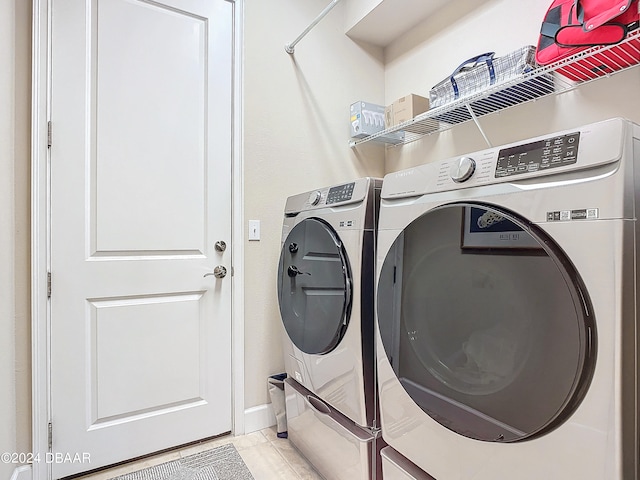 washroom with washing machine and dryer and light tile patterned flooring