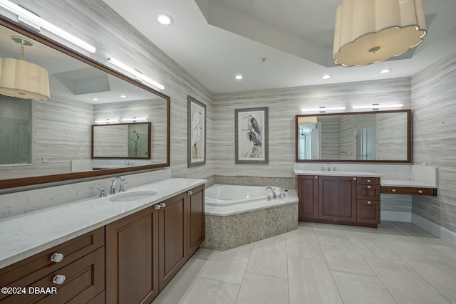 bathroom featuring tile patterned flooring, vanity, and a relaxing tiled tub