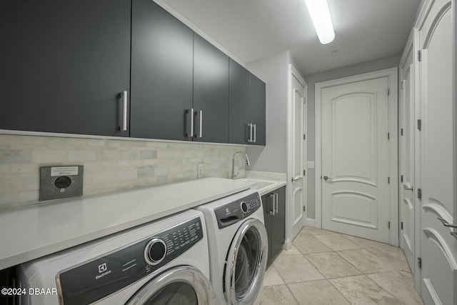 washroom with light tile patterned flooring, cabinets, separate washer and dryer, and sink