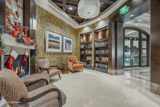 living area featuring beamed ceiling, a high ceiling, built in features, and coffered ceiling