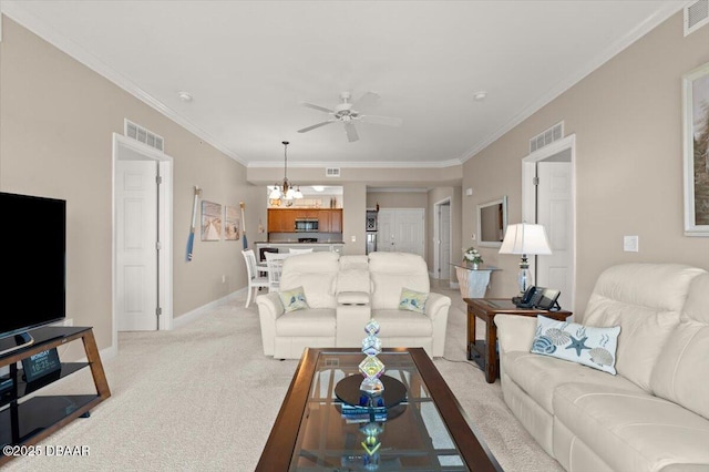 carpeted living room featuring ceiling fan with notable chandelier and ornamental molding