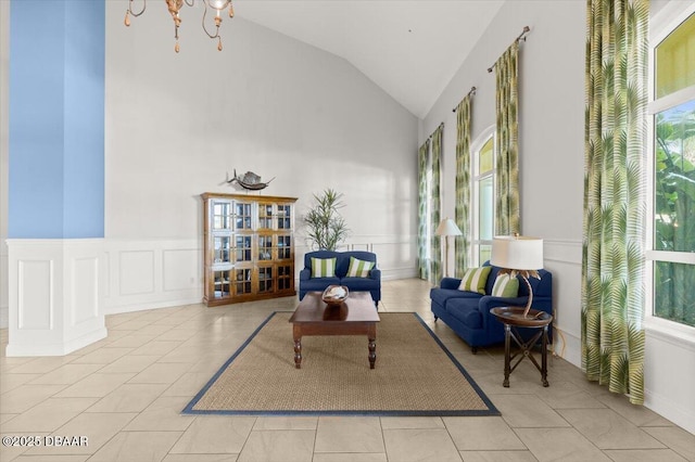 living area featuring an inviting chandelier, high vaulted ceiling, light tile patterned flooring, and a healthy amount of sunlight