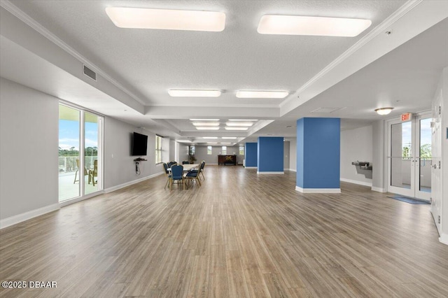 interior space featuring a textured ceiling, ornamental molding, and wood-type flooring