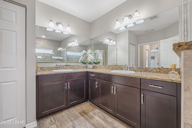 10 Creek Ct, Palm Coast, FL 32137 - full bath featuring double vanity, a sink, wood finished floors, and visible vents
