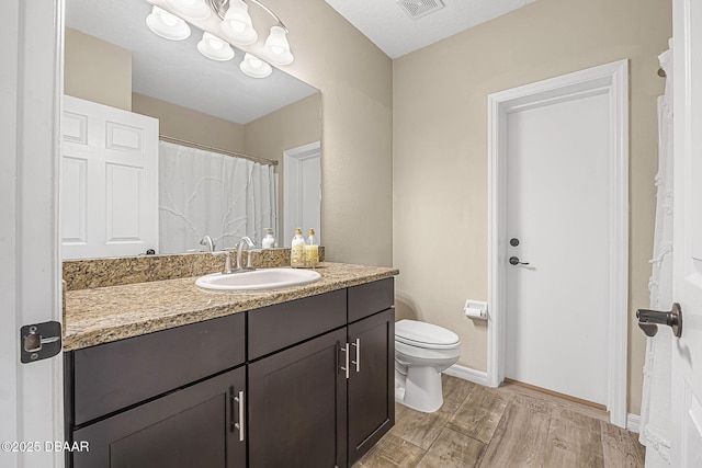 10 Creek Ct, Palm Coast, FL 32137 - bathroom featuring visible vents, baseboards, toilet, wood finished floors, and vanity