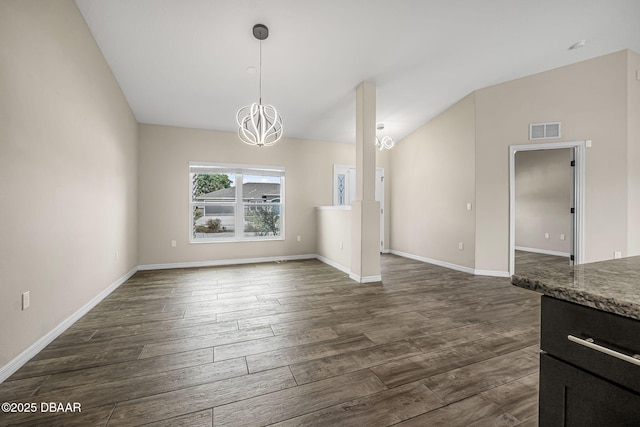 10 Creek Ct, Palm Coast, FL 32137 - unfurnished dining area featuring dark wood finished floors, vaulted ceiling, baseboards, visible vents, and a notable chandelier