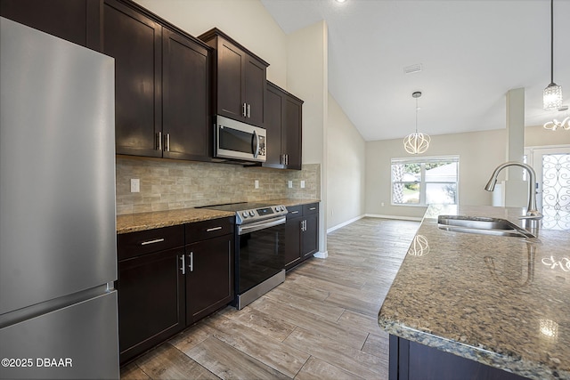 10 Creek Ct, Palm Coast, FL 32137 - kitchen with tasteful backsplash, appliances with stainless steel finishes, vaulted ceiling, stone counters, and a sink