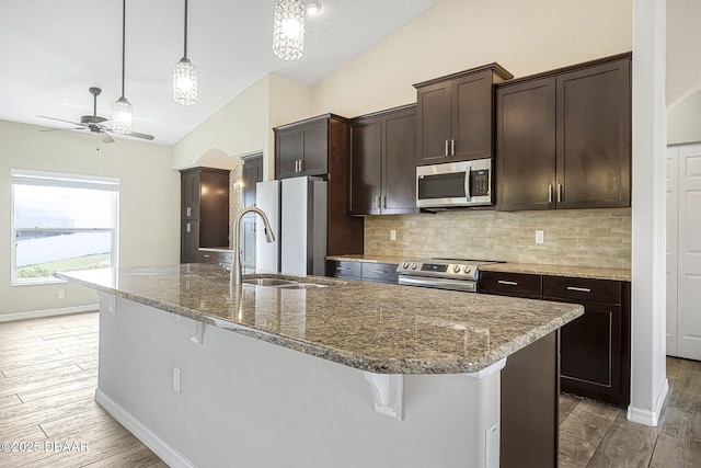 10 Creek Ct, Palm Coast, FL 32137 - kitchen with tasteful backsplash, ceiling fan, stainless steel appliances, dark brown cabinetry, and vaulted ceiling