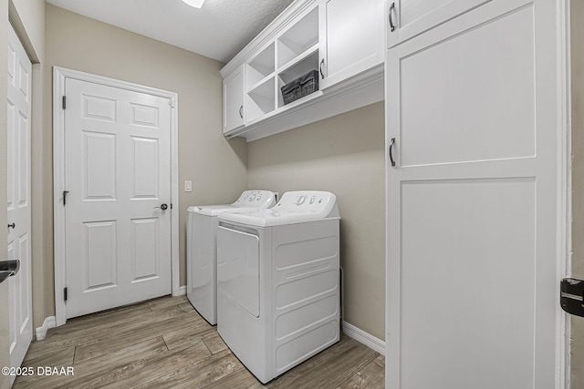 10 Creek Ct, Palm Coast, FL 32137 - laundry area featuring light wood finished floors, independent washer and dryer, cabinet space, and baseboards