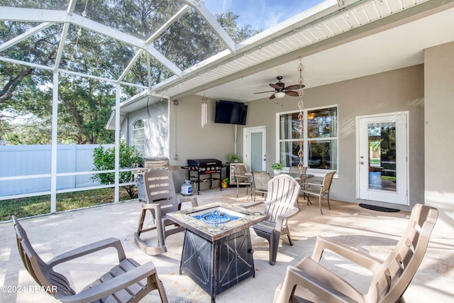 sunroom / solarium with ceiling fan, a healthy amount of sunlight, and vaulted ceiling