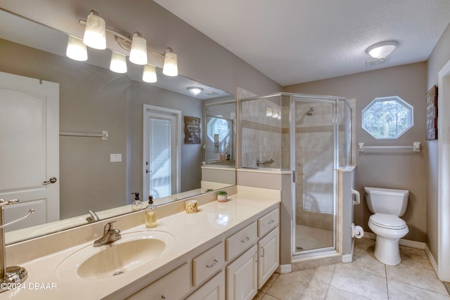 bathroom with tile patterned floors, vanity, a textured ceiling, a shower with door, and toilet