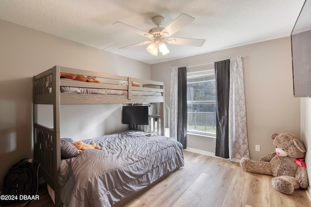 bedroom featuring a textured ceiling, light hardwood / wood-style flooring, and ceiling fan