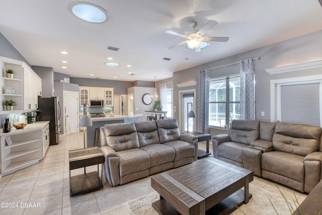 tiled living room with ceiling fan and a textured ceiling