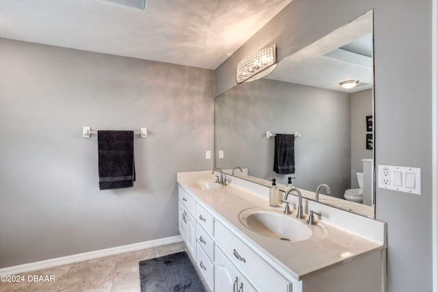 bathroom with tile patterned flooring, vanity, and toilet