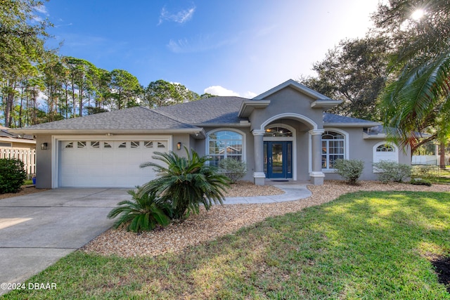 view of front of home with a front lawn and a garage