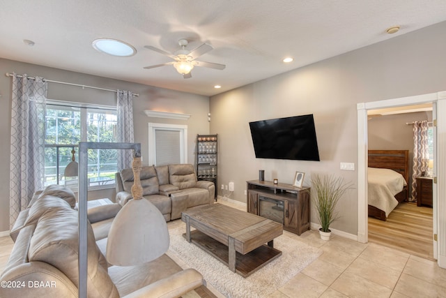 tiled living room with ceiling fan and a textured ceiling