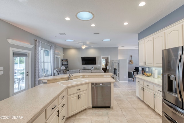 kitchen featuring ceiling fan, sink, light tile patterned floors, and stainless steel appliances