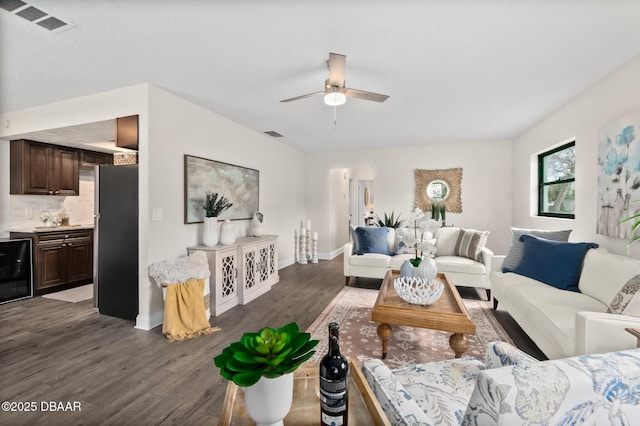 living area featuring visible vents, baseboards, wine cooler, dark wood-style floors, and a ceiling fan