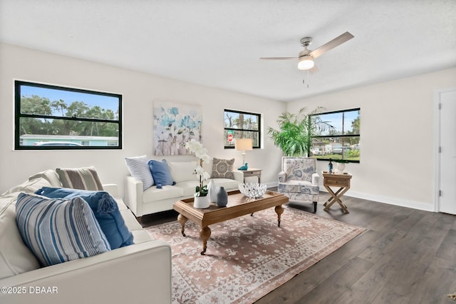 living room featuring wood finished floors, baseboards, a wealth of natural light, and ceiling fan