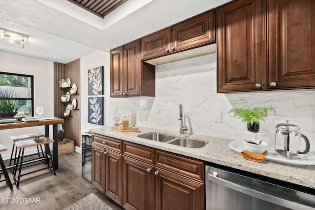 kitchen featuring light stone countertops, dark wood-style floors, a sink, dishwasher, and backsplash