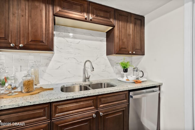 kitchen with light stone counters, a sink, decorative backsplash, dark brown cabinetry, and stainless steel dishwasher