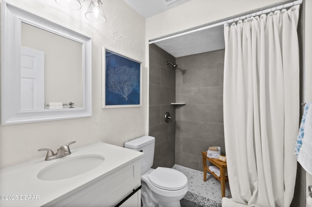 full bathroom with vanity, toilet, and tiled shower