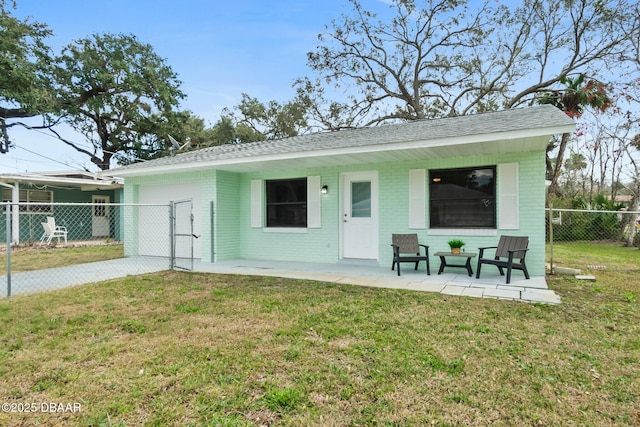 back of house with a lawn, brick siding, and fence