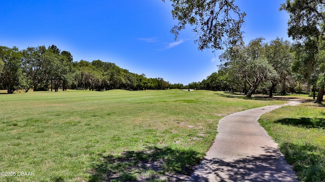 surrounding community with a yard and view of golf course