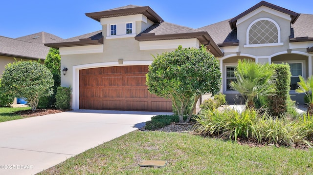 view of front of house with concrete driveway, a garage, a shingled roof, and stucco siding