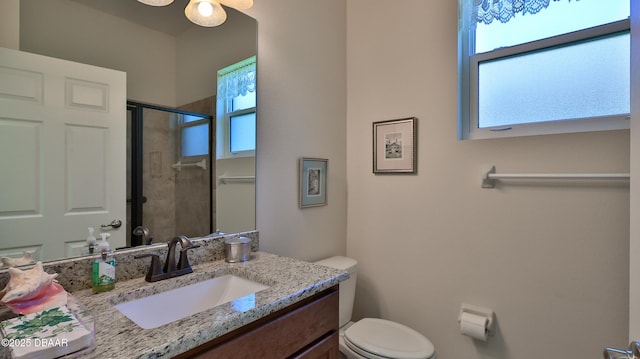 full bathroom featuring vanity, plenty of natural light, a stall shower, and toilet