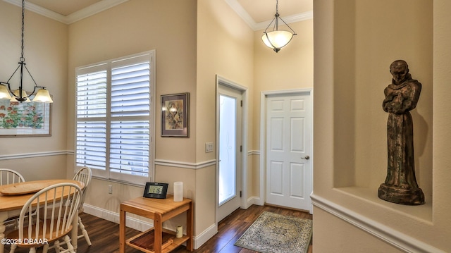 entryway featuring crown molding, dark wood finished floors, baseboards, and an inviting chandelier