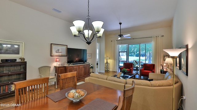 living area featuring visible vents, wood finished floors, and ceiling fan with notable chandelier